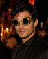 Antique gold Golden Foundry steampunk goggles with dark round lenses, distressed metallic frames, decorative side vents, and adjustable black strap.