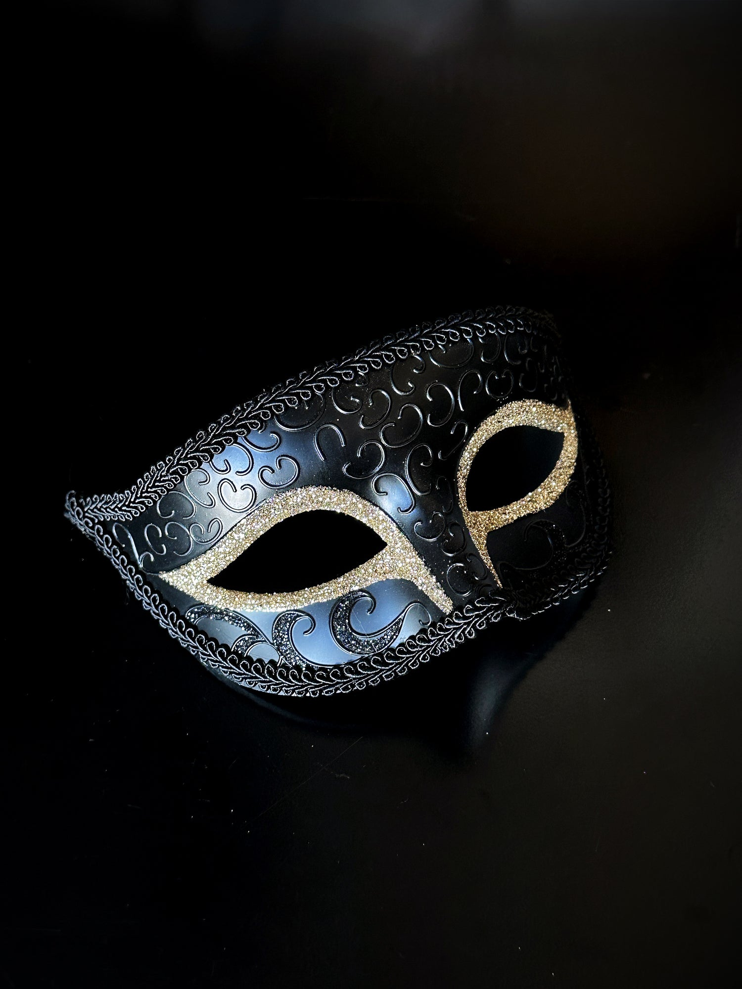Mens Venetian masquerade mask in black with champagne glitter eyes.
