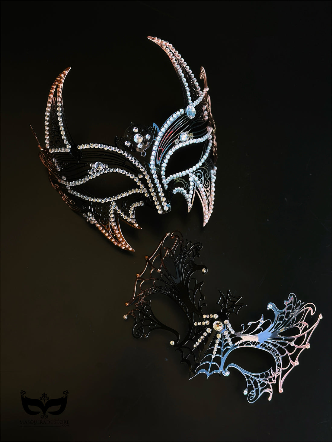 Midnight Inferno Halloween couples mask set with black rhinestone horned mask and black silver spiderweb filigree mask with crystal accents.