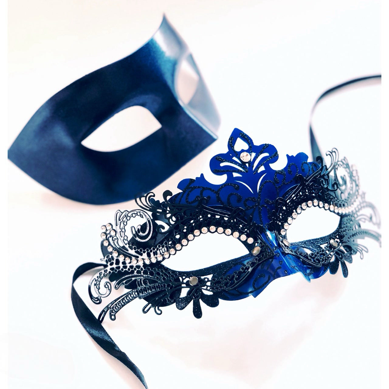 Couples masquerade masks in blue and black with filigree rhinestone detailing and matte satin finish.
