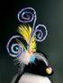 Black mini hat with spring-themed eggs, feathers, and sparkly spirals for Easter events