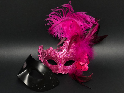 Elegant black couples masquerade mask set with feathered women’s mask and men’s classic mask, available in pink.