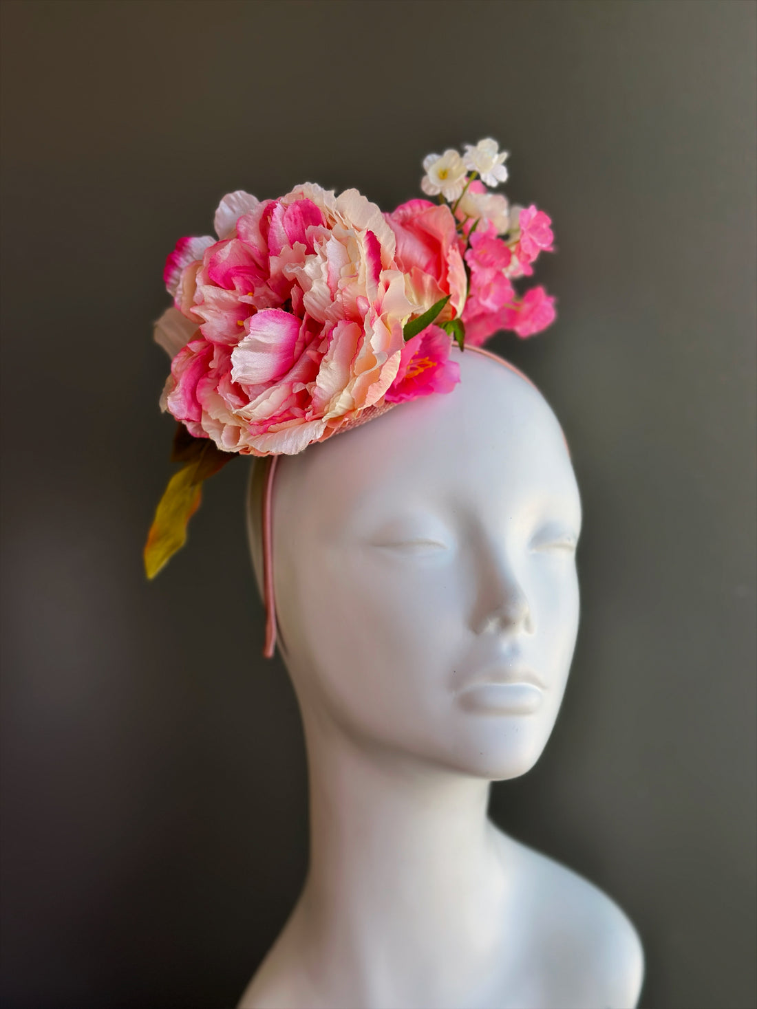 Pink peony fascinator hat with layered flowers for derby, wedding, and garden party occasions.