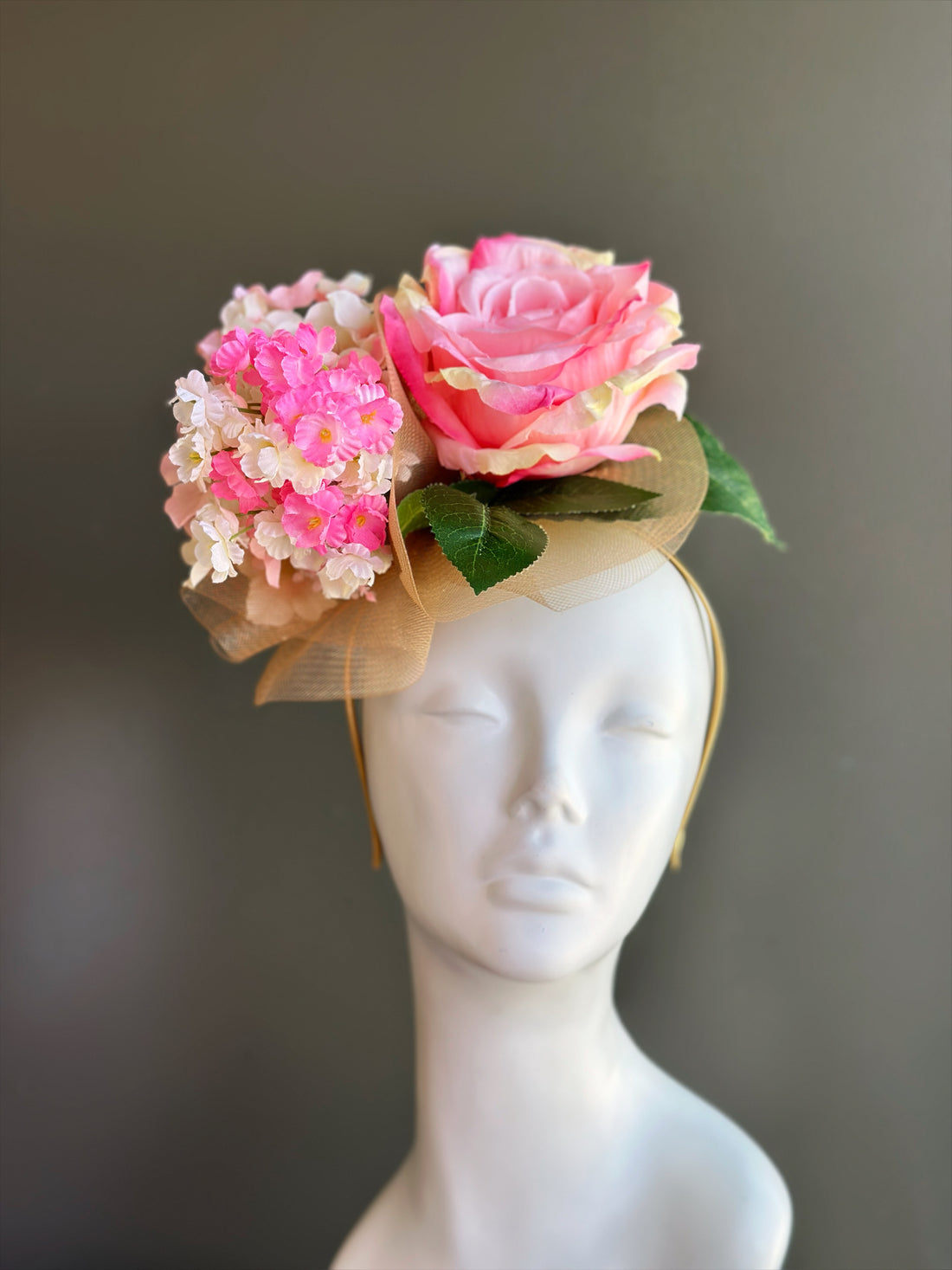 Pink rose fascinator hat with layered flowers for derby, wedding, and garden party occasions.