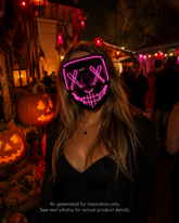 Pink Voltage LED light-up mask with glowing pink X eyes, stitched smile design, full-face shape, replaceable battery, and three lighting settings.