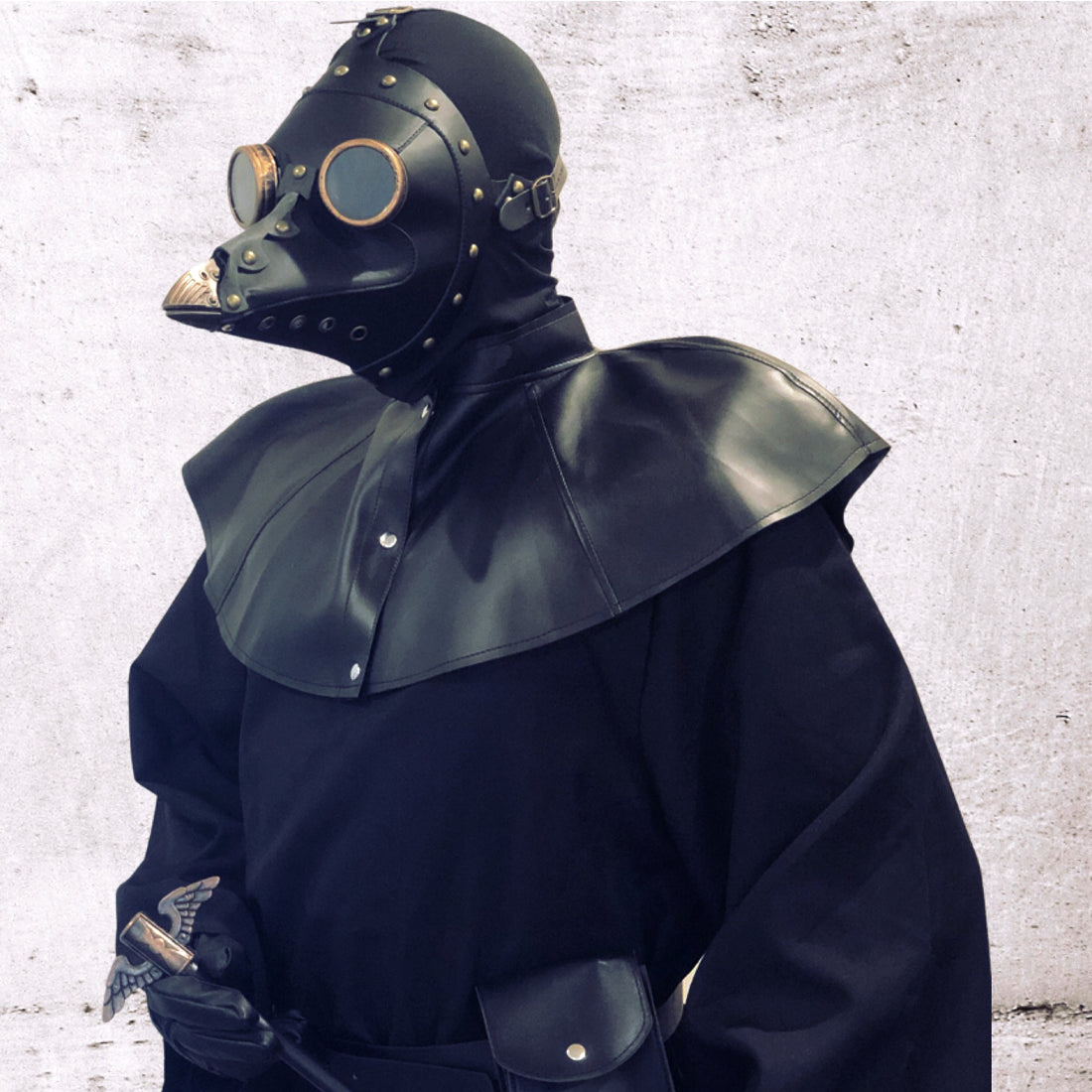 Man in gothic black leather plague doctor mask and robe with walking stick