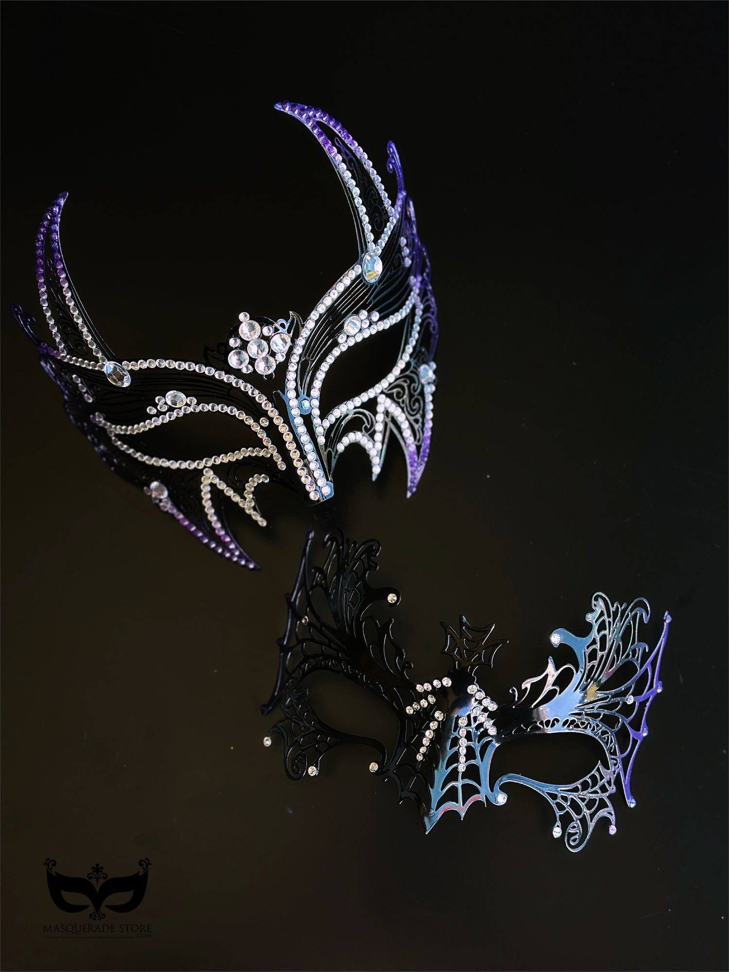 Purple and black couples masquerade mask set with a horned rhinestone masquerade mask and a spiderweb-style eye mask for gothic formal events.