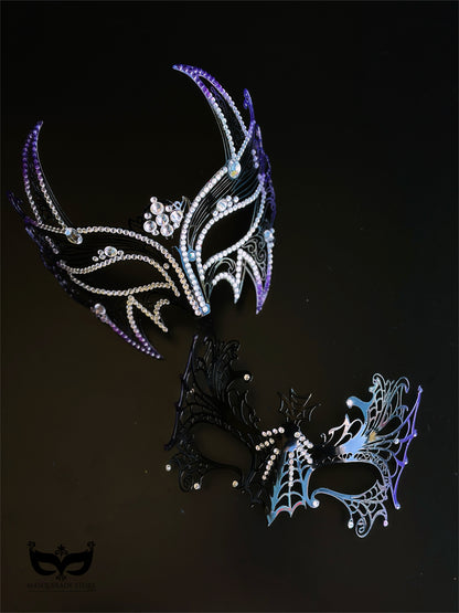 Purple and black couples masquerade mask set with a horned rhinestone masquerade mask and a spiderweb-style eye mask for gothic formal events.