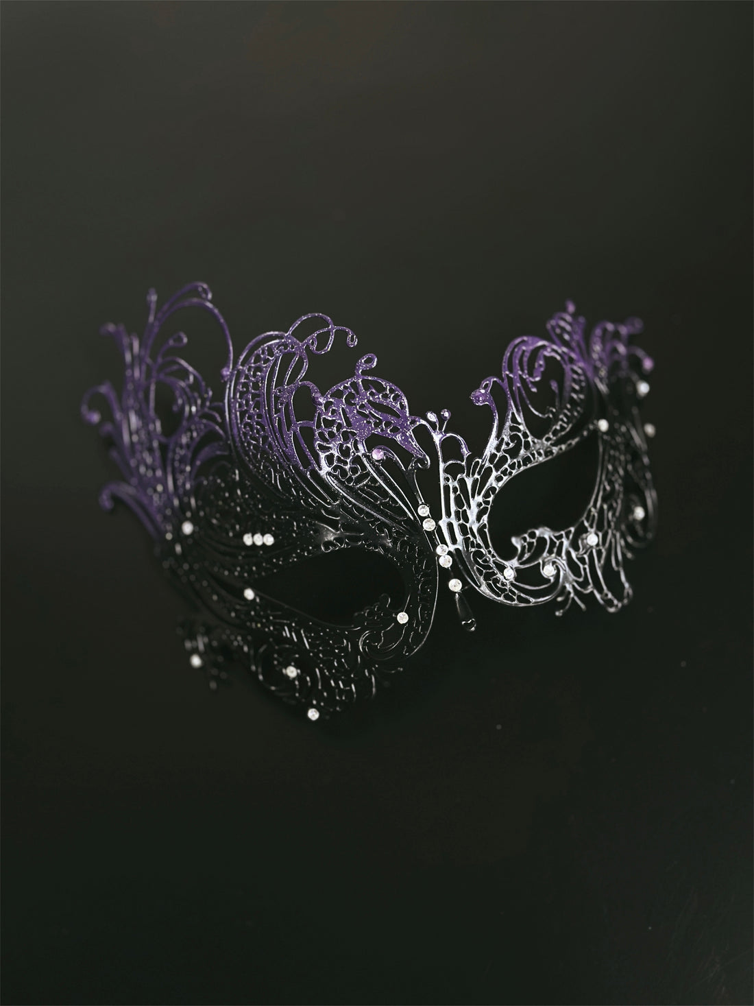 Purple and black women’s masquerade mask with metal filigree design and rhinestones, ideal for Venetian masquerade balls, Mardi Gras, and Halloween parties.