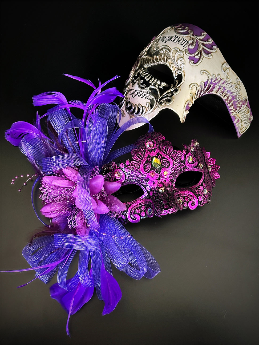 Couples masquerade mask set featuring purple feathered mask for women and white sculpted skull mask for men
