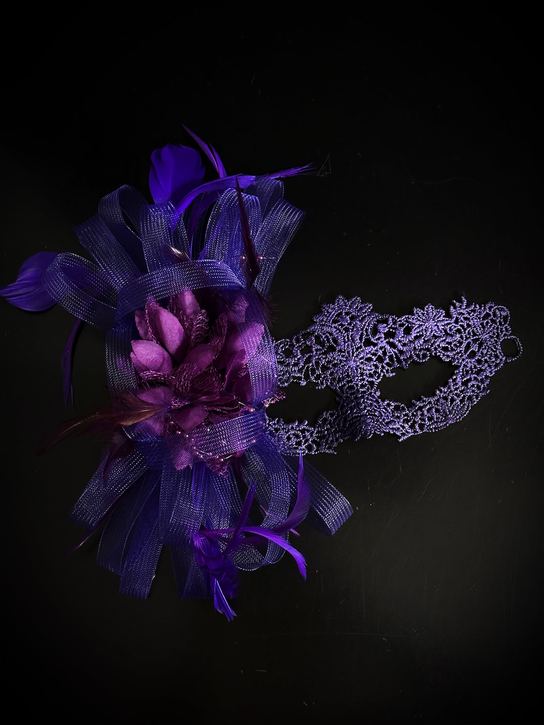Purple lace masquerade mask with feathers, floral accent, and tulle, ideal for prom, masquerade ball, or Halloween.