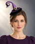 Purple Spellbound Witch Hat Fascinator with glitter finish, curled tip, dangling black spider, and floral embellishment.