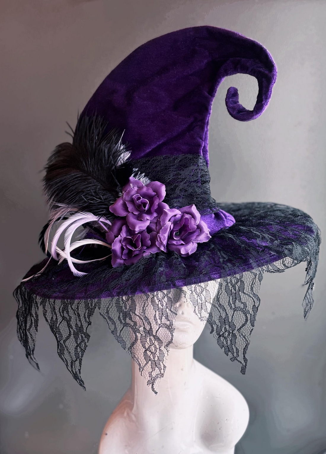 Purple witch hat with lace veil, roses, and feathers for Halloween and gothic costumes.