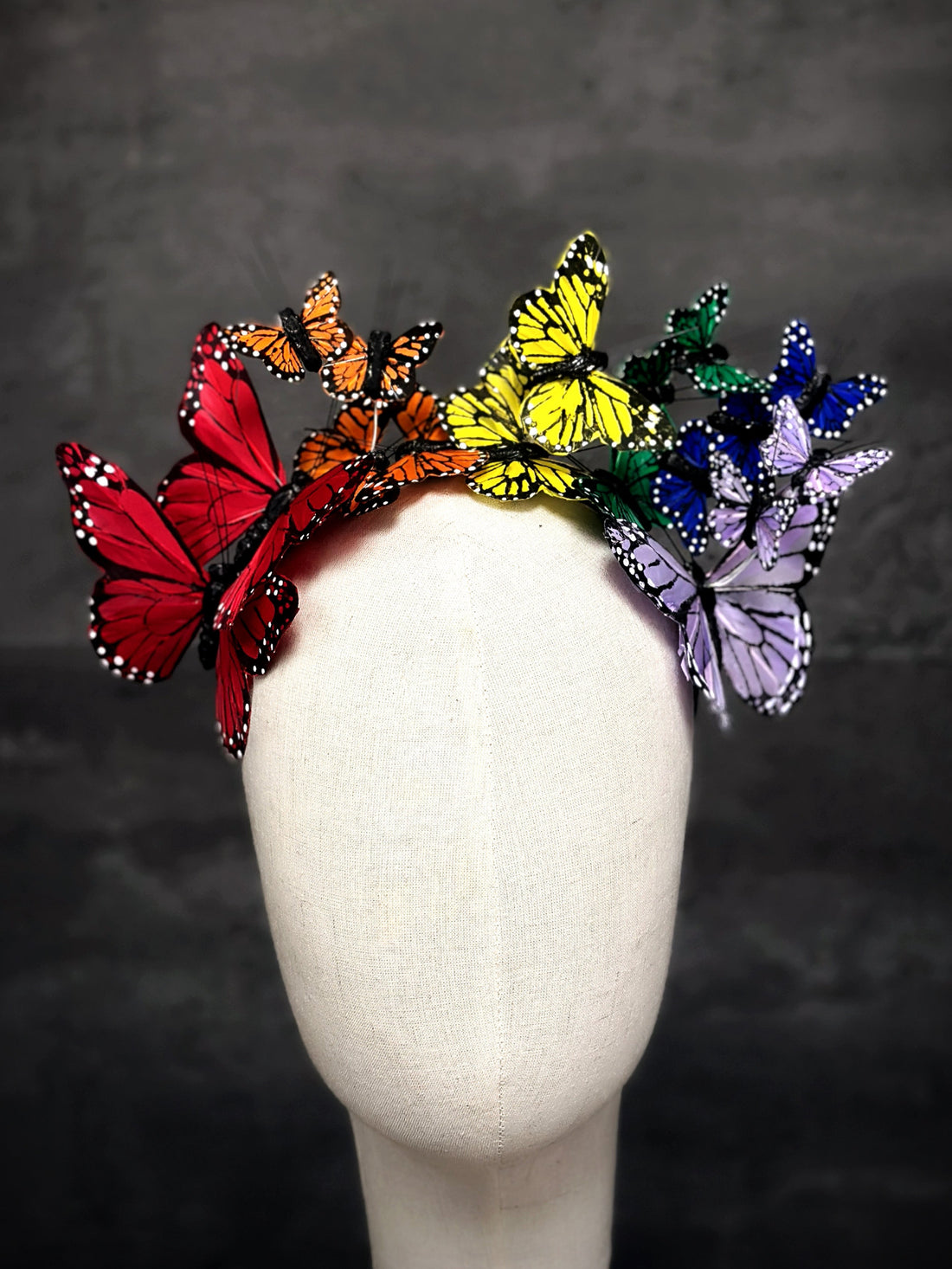 Colorful butterfly crown featuring red, orange, yellow, green, blue, and purple butterflies for Pride or festivals