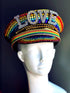Rainbow rhinestone captain hat with LOVE statement letters, designed for Pride, drag, and festival costumes