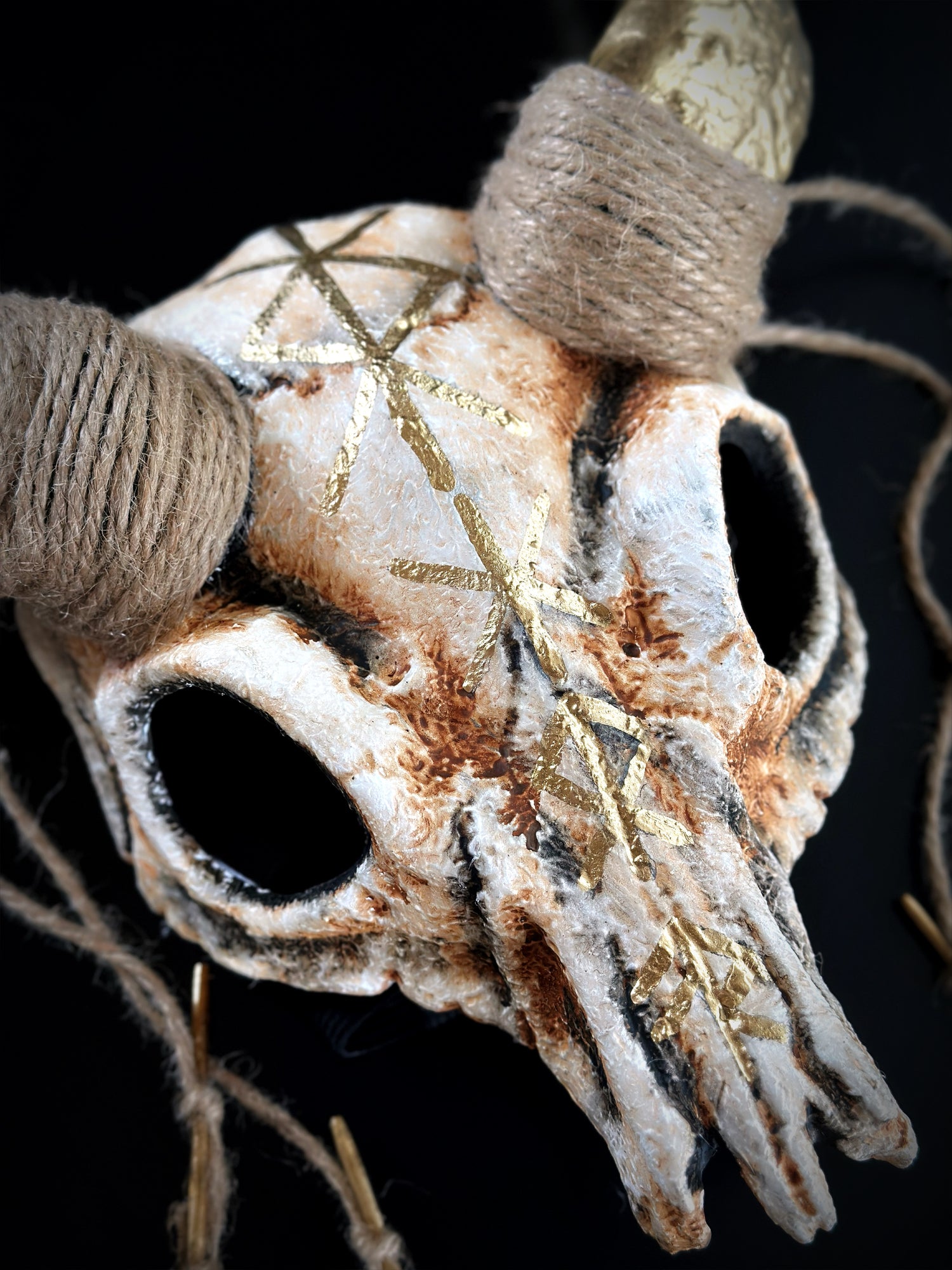 Halloween costume mask with ram skull design, golden runes, and twine horns