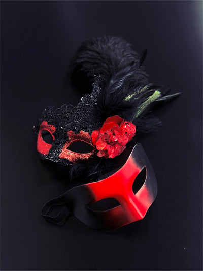 Red and black masquerade couples masks, one with lace, glitter, feathers, and a red floral accent, perfect for Venetian masquerade balls and Mardi Gras.