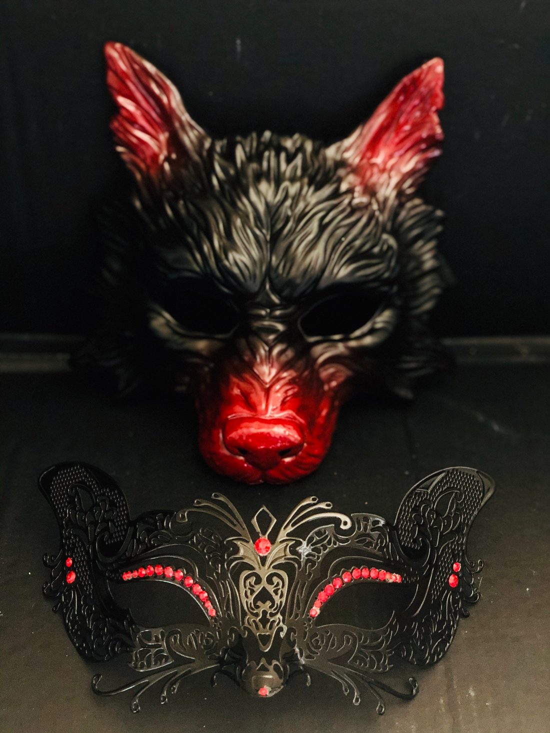 Red and black couples masquerade masks with filigree rhinestones and bold sculpted detail.
