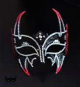 Red and black horned masquerade mask with rhinestone accents, curved horn points, ribbon ties, and gothic Venetian-inspired styling for formal events.