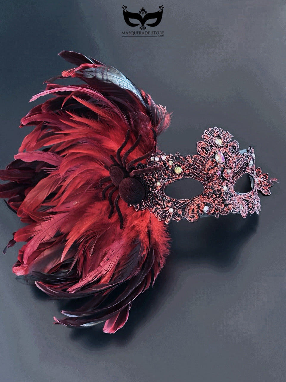 Red feather Venetian masquerade mask with rhinestones and spider detail for women.