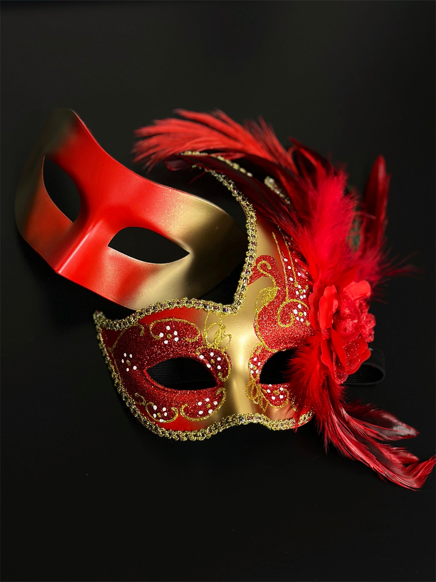 Red and gold masquerade couples masks, one with feathers and glitter detailing, ideal for Venetian masquerade balls, prom, and Mardi Gras celebrations.