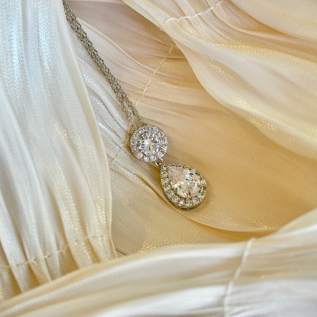 Sparkly silver necklace with teardrop and round rhinestone pendants for formal or bridal wear