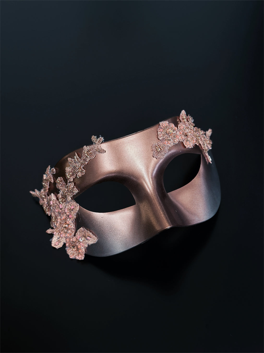 Rose gold Venetian masquerade mask with floral lace and beaded appliqué.
