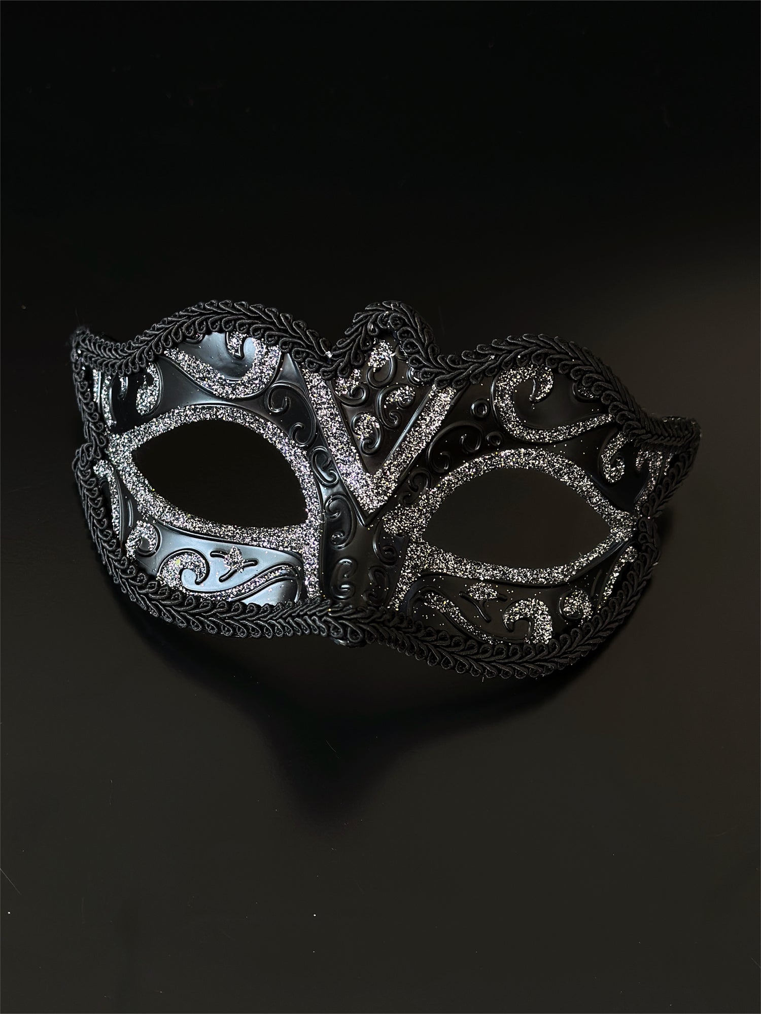 Black Venetian masquerade mask with silver glitter scroll design for elegant formal events.