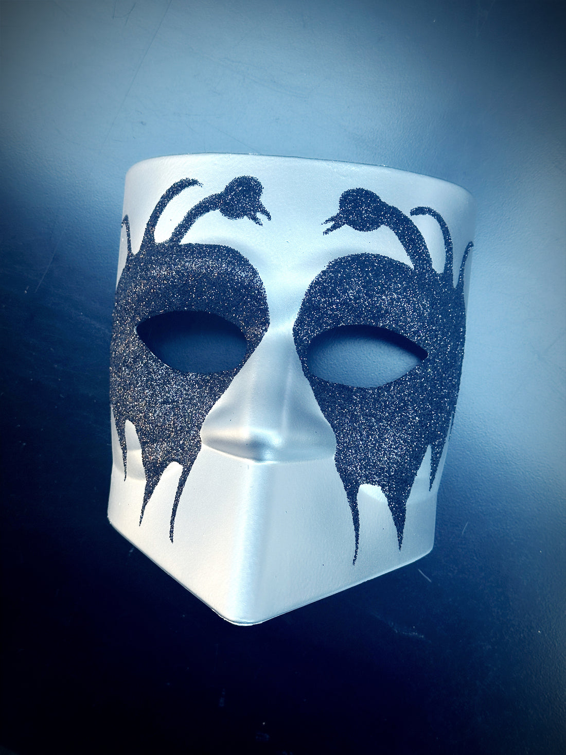 Silver Venetian Bauta masquerade mask with black glitter serpent design for Halloween or carnival events.