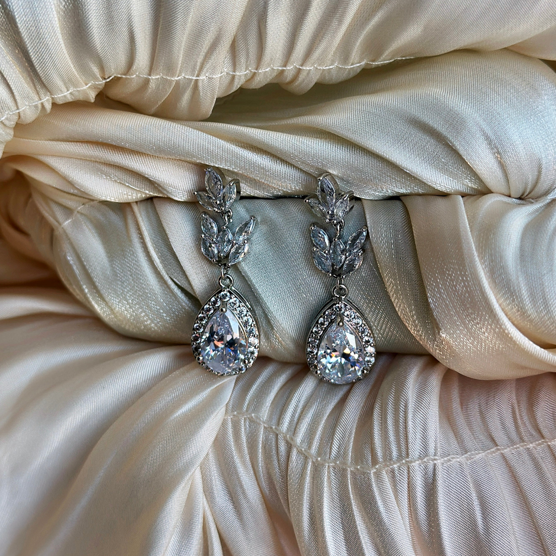 Crystal drop earrings with silver flower detailing for weddings, parties, or formal fashion styling