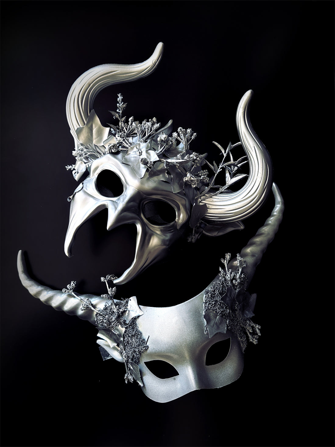 Metallic masquerade masks with horns and vine embellishments for fantasy couples