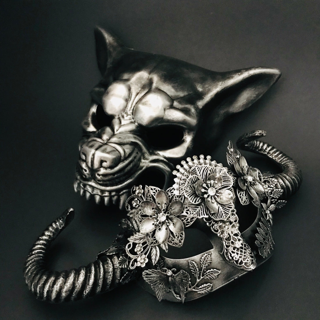 Elegant silver masquerade mask pair featuring gothic wolf design and sculpted horn floral lace mask.