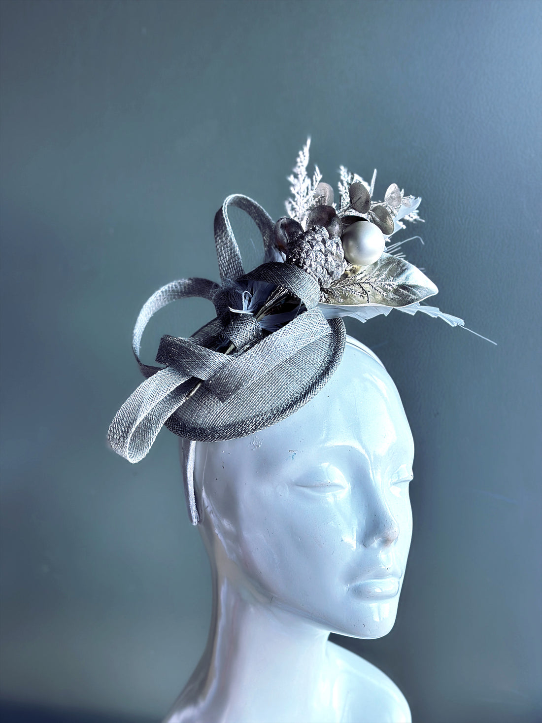 Masquerade-ready silver fascinator with pinecones, florals, and ribbon accents