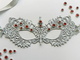 Silver lace masquerade mask with ruby red rhinestones for Venetian gala and formal ballroom events.