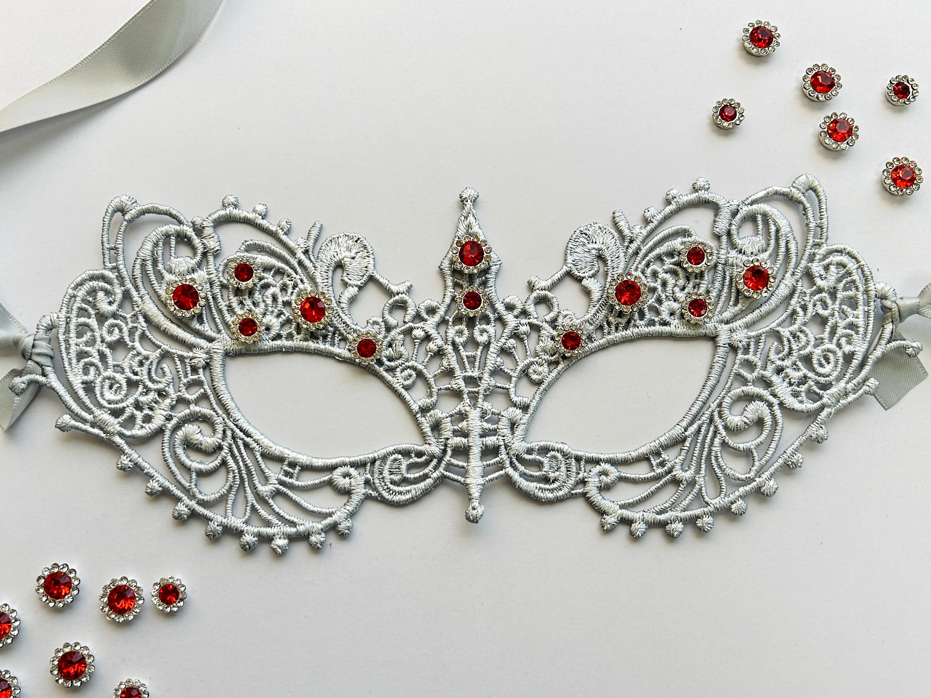 Silver lace masquerade mask with ruby red rhinestones for Venetian gala and formal ballroom events.