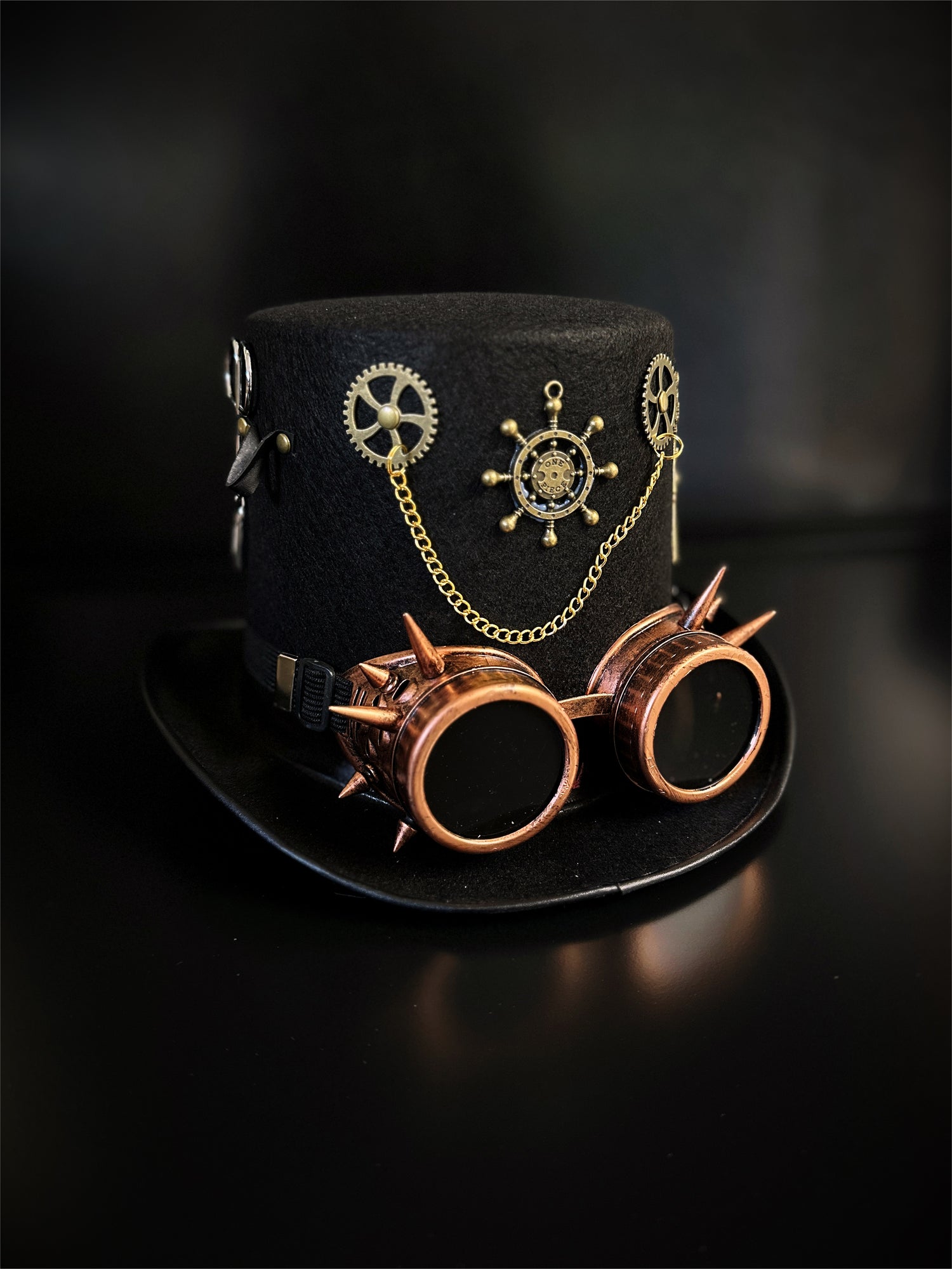 Black steampunk hat with copper spiked goggles and steampunk motifs.