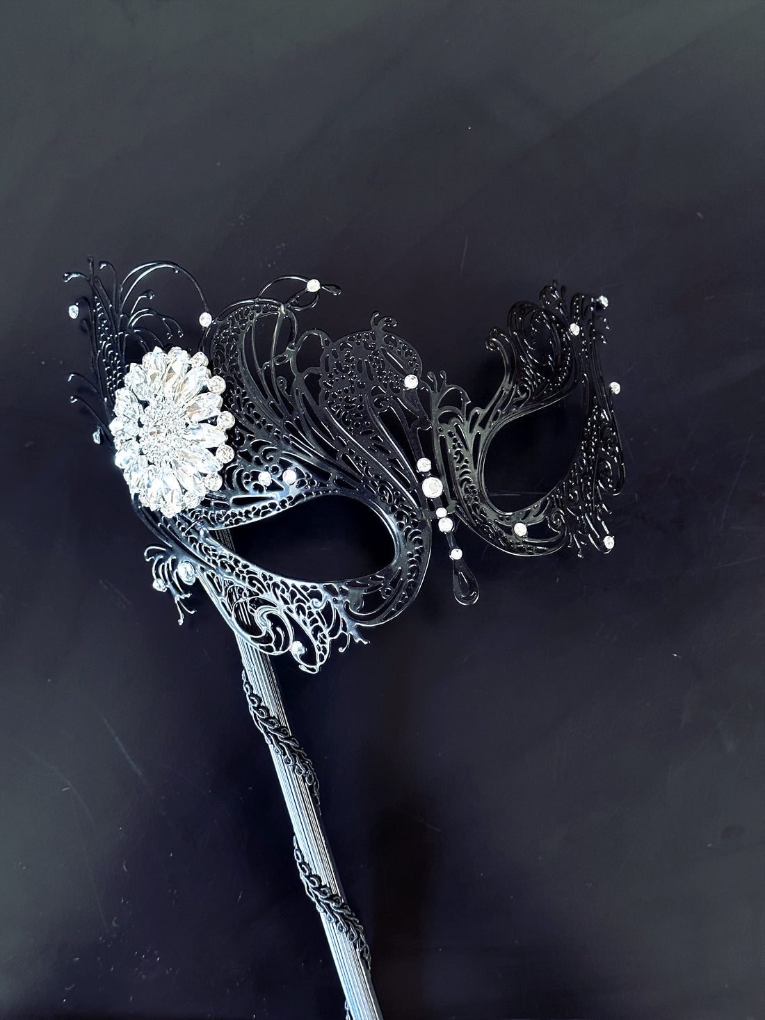 Swan black metal handheld mask with white brooch, it will be the perfect finishing touch to you ensemble!