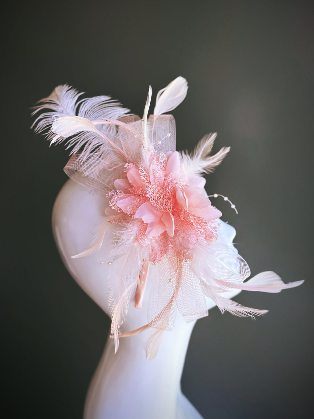 Peach pink fascinator hat with feathers and tulle on headband

