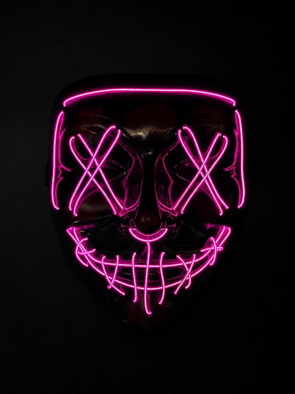 Pink Voltage LED light-up mask with glowing pink X eyes, stitched smile design, full-face shape, replaceable battery, and three lighting settings.