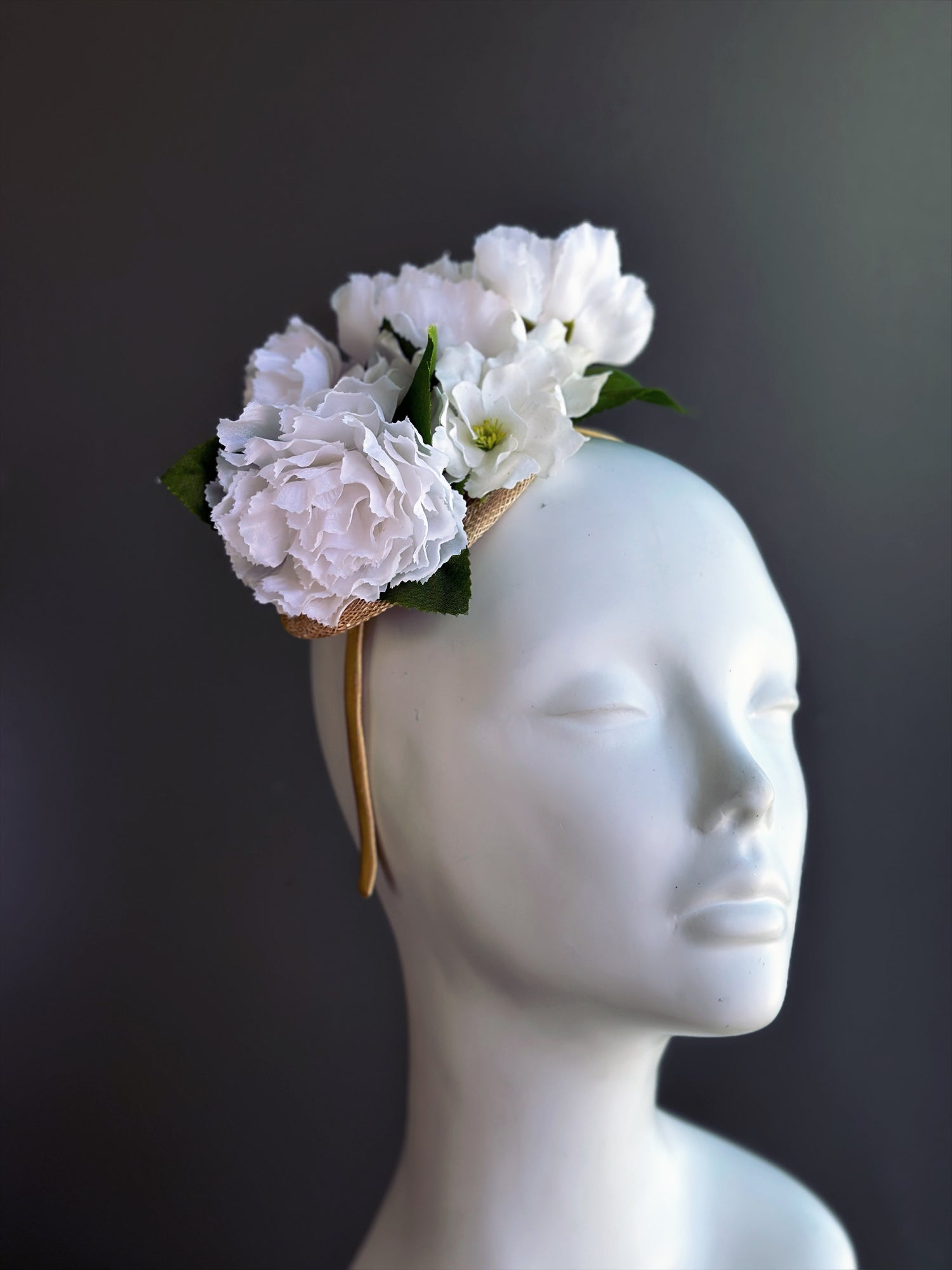 White floral fascinator hat with blossoms for weddings, bridal events, and derby occasions.