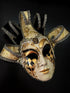 Elegant jester-style masquerade mask with white, gold, and harlequin design fabric curls.