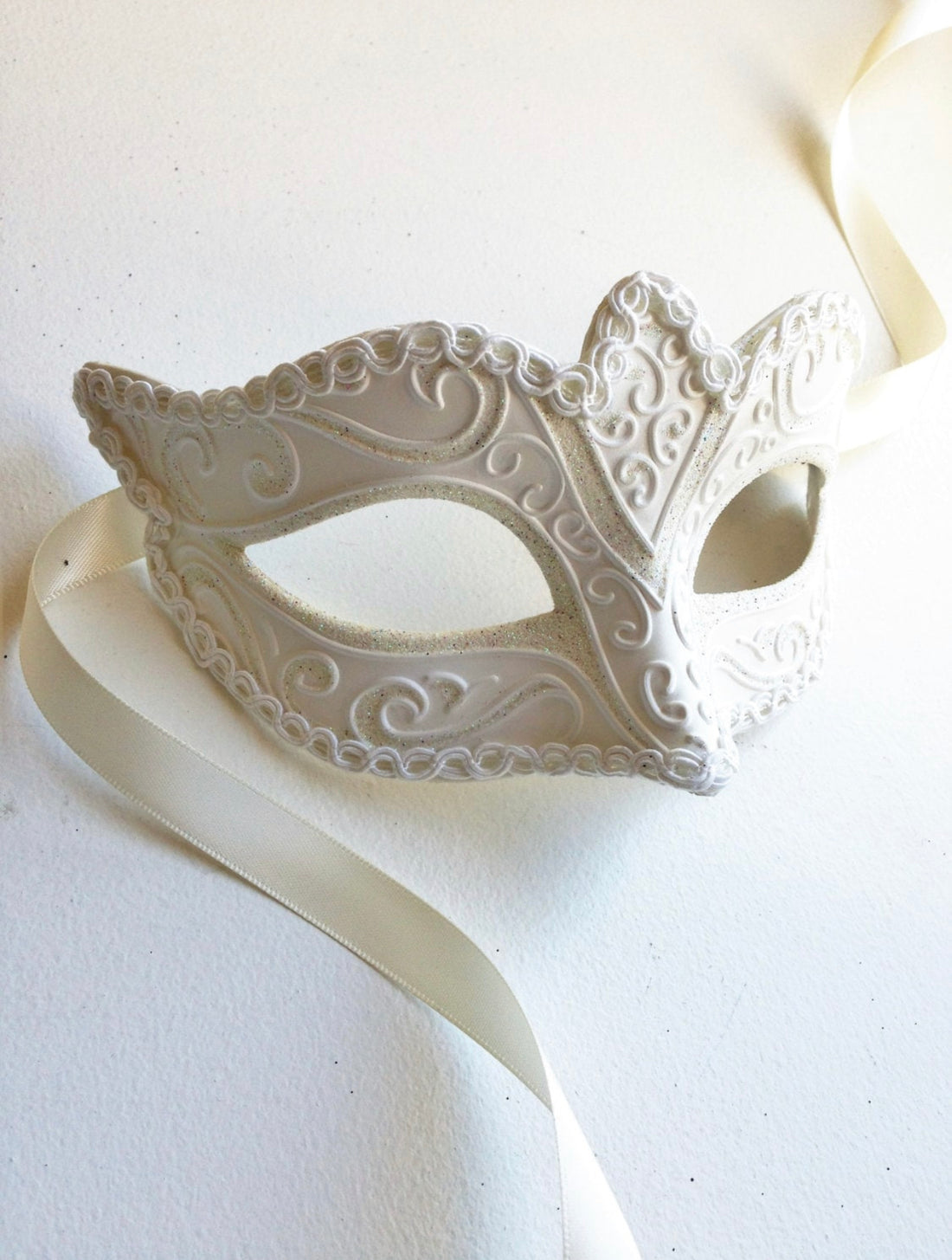White women masquerade mask with glitter.