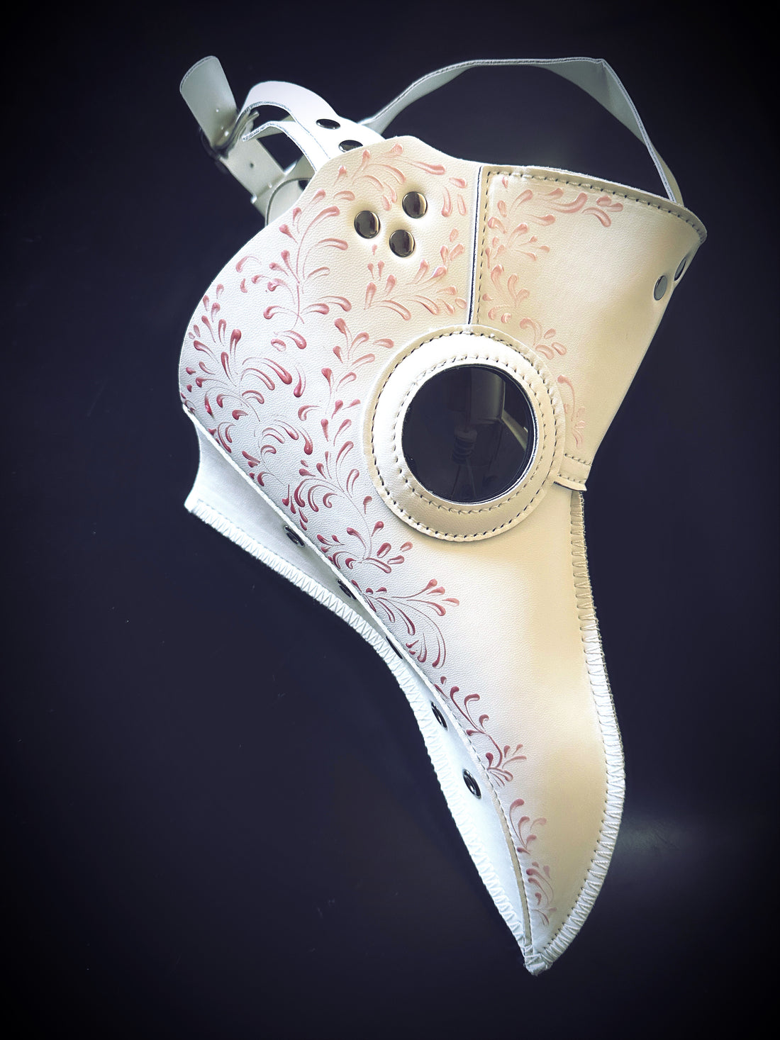 White plague mask with pink filigree.