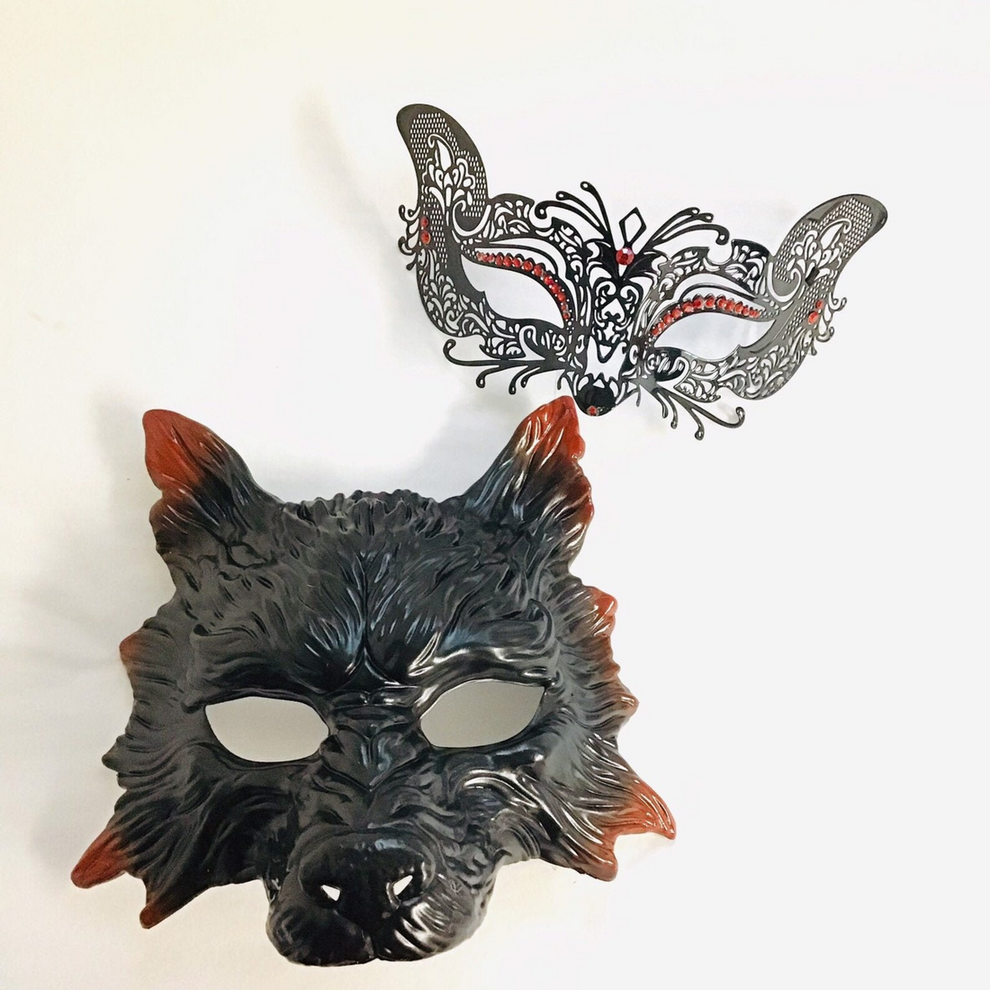 Wolf and kitty masquerade mask set with a black wolf mask for men and a lace bunny mask with red rhinestones for women.