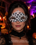 Haunted Filigree black and white metal masquerade mask with ornate open scrollwork, crystal rhinestone trim, pointed details, and Halloween styling.