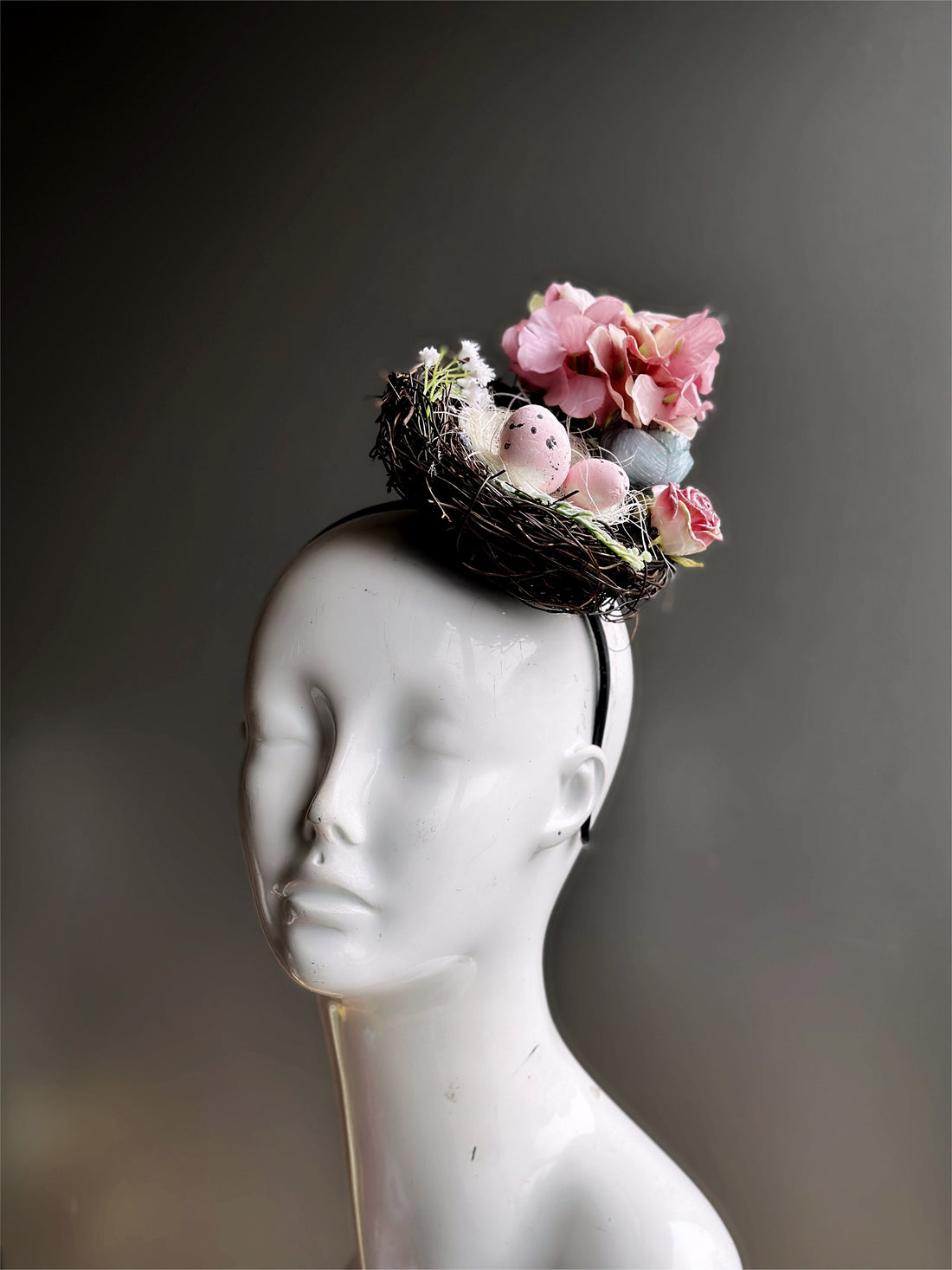 Easter Fascinator Hat in Bird nest design with pink eggs and blue and pink flowers.