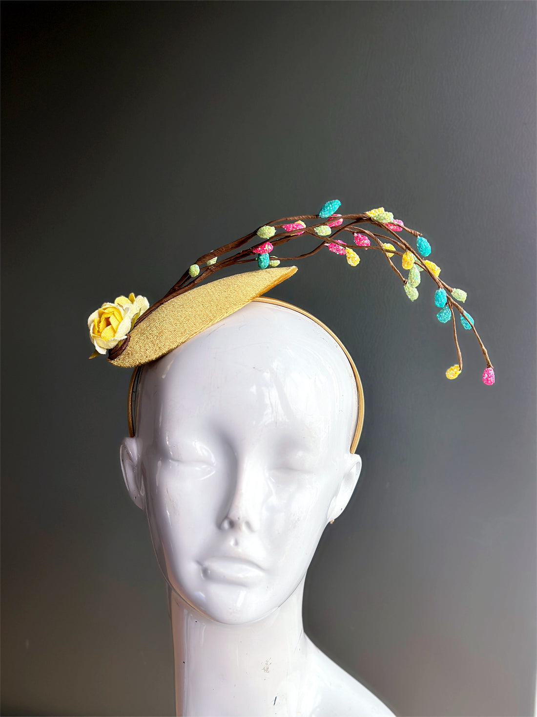 Easter Fasinator hat with yellow flowers and colorful bulbs.