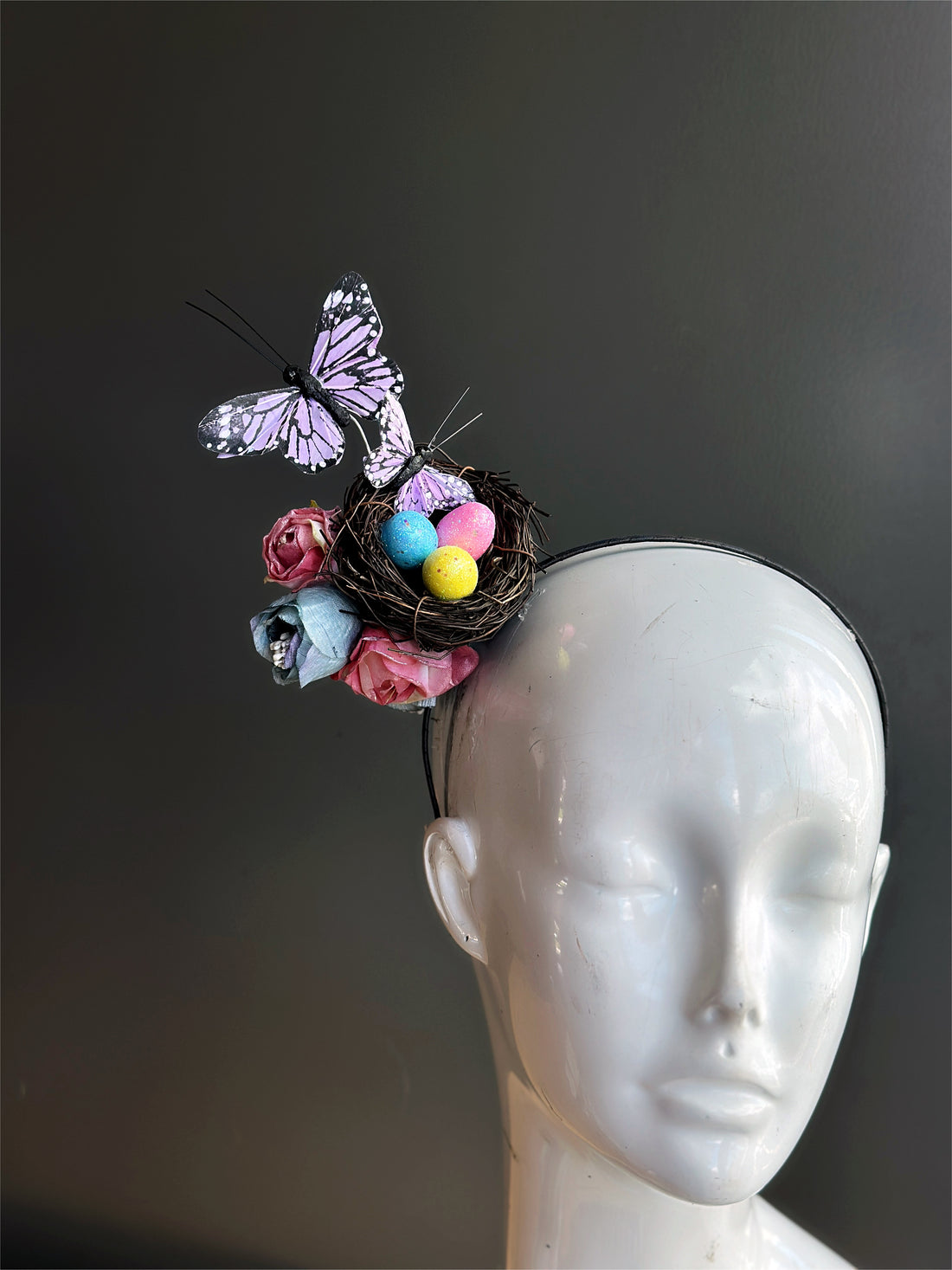 Headband with a nest full of colorful Easter eggs, purple butterflies, and flowers.