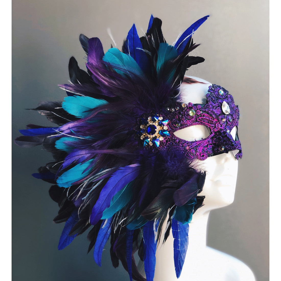 Womens feather masquerade mask with blue and purple feathers and gems, for sale.