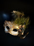 Womens gold masquerade mask with a cracked design and feathers.